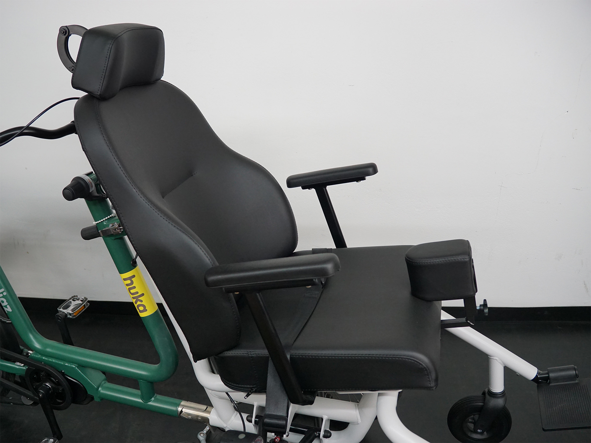 Komfortabler Therapiesitz mit Kopfstütze, Armlehnen und Beinstütze, montiert auf einem Huka-Therapierad.