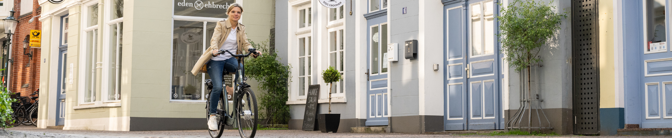 Frau fährt ein Fahrrad mit tiefen Einstieg durch eine Stadt