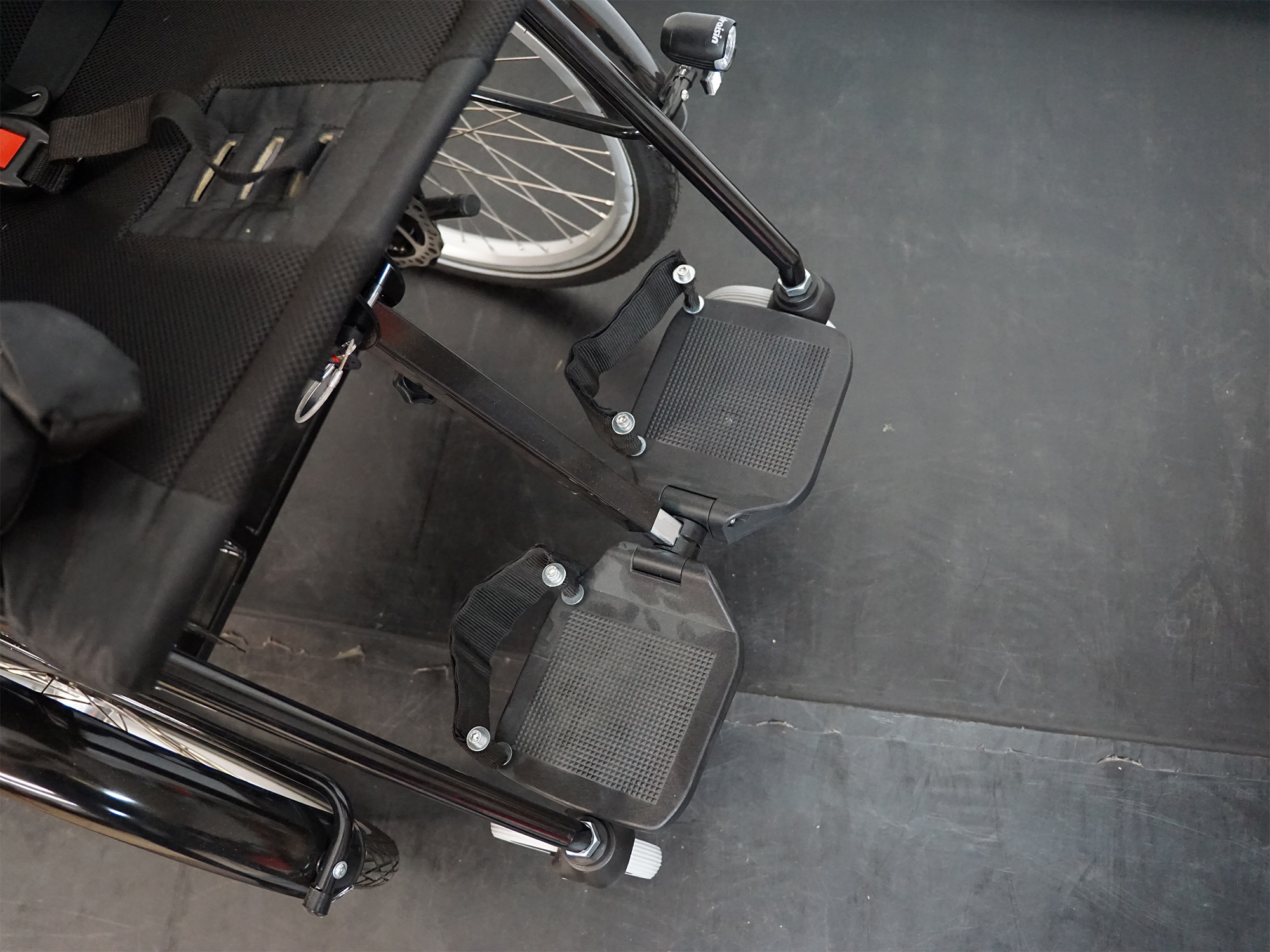 Fußstützen eines Therapierads mit rutschfestem Belag, höhenverstellbar und sicher fixiert.