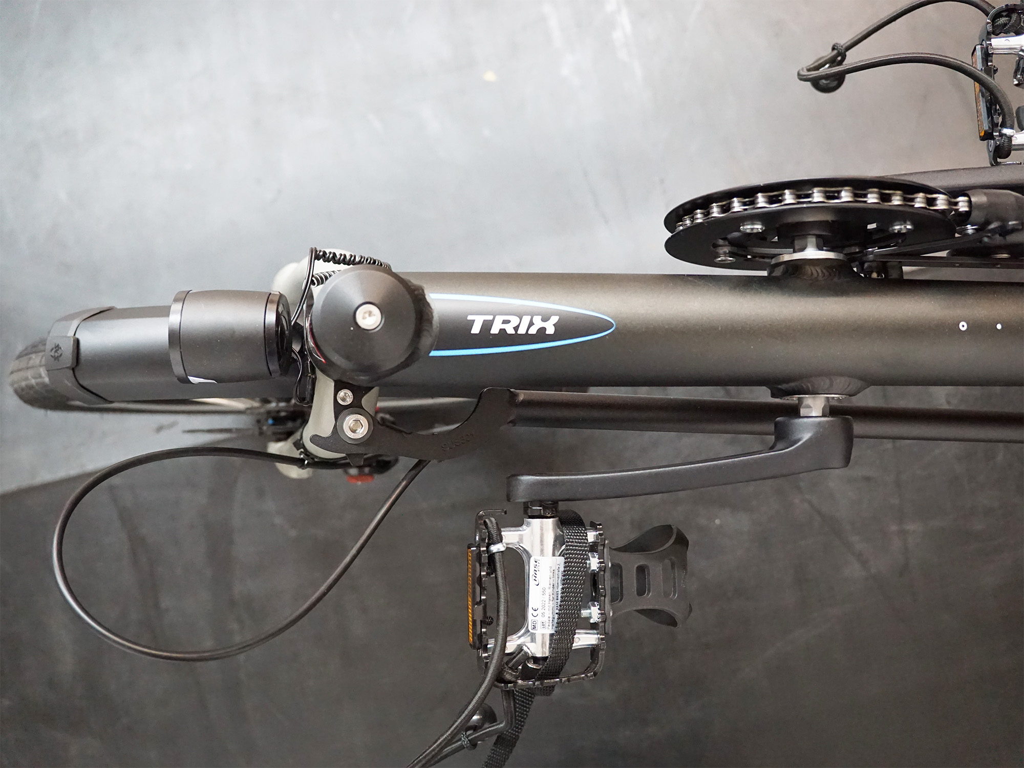 Oberansicht des schwarzen Liegeradrahmens mit „TRIX“-Schriftzug, Pedal, Kurbel und Schaltungskomponenten