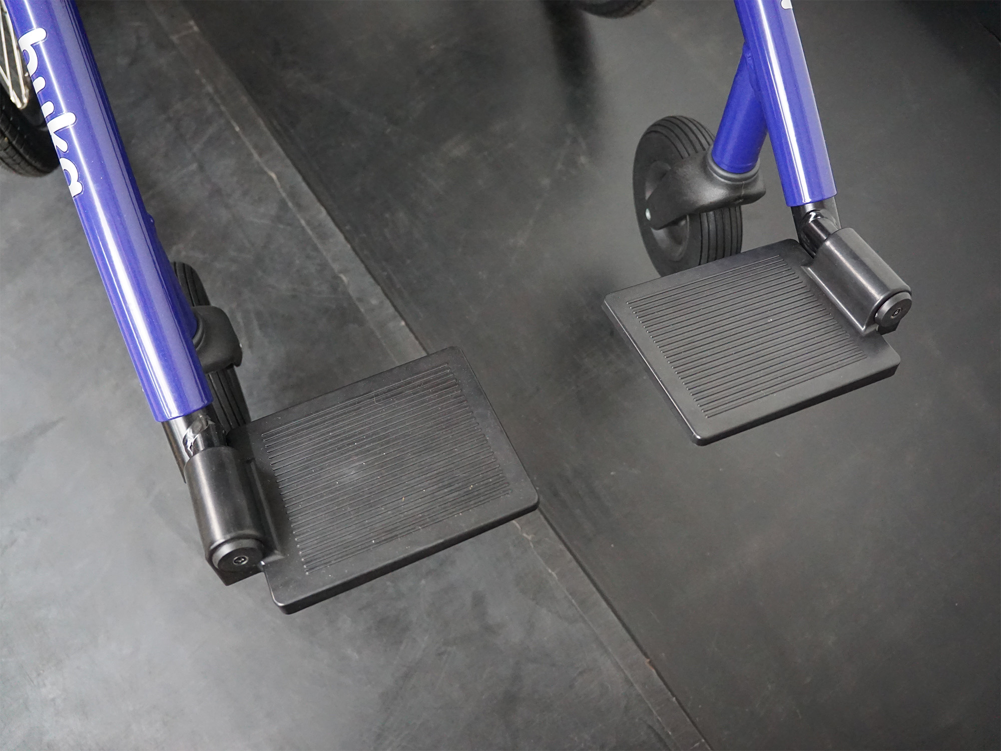 Fußstützen eines Therapierads mit rutschfestem Belag, höhenverstellbar und sicher fixiert.