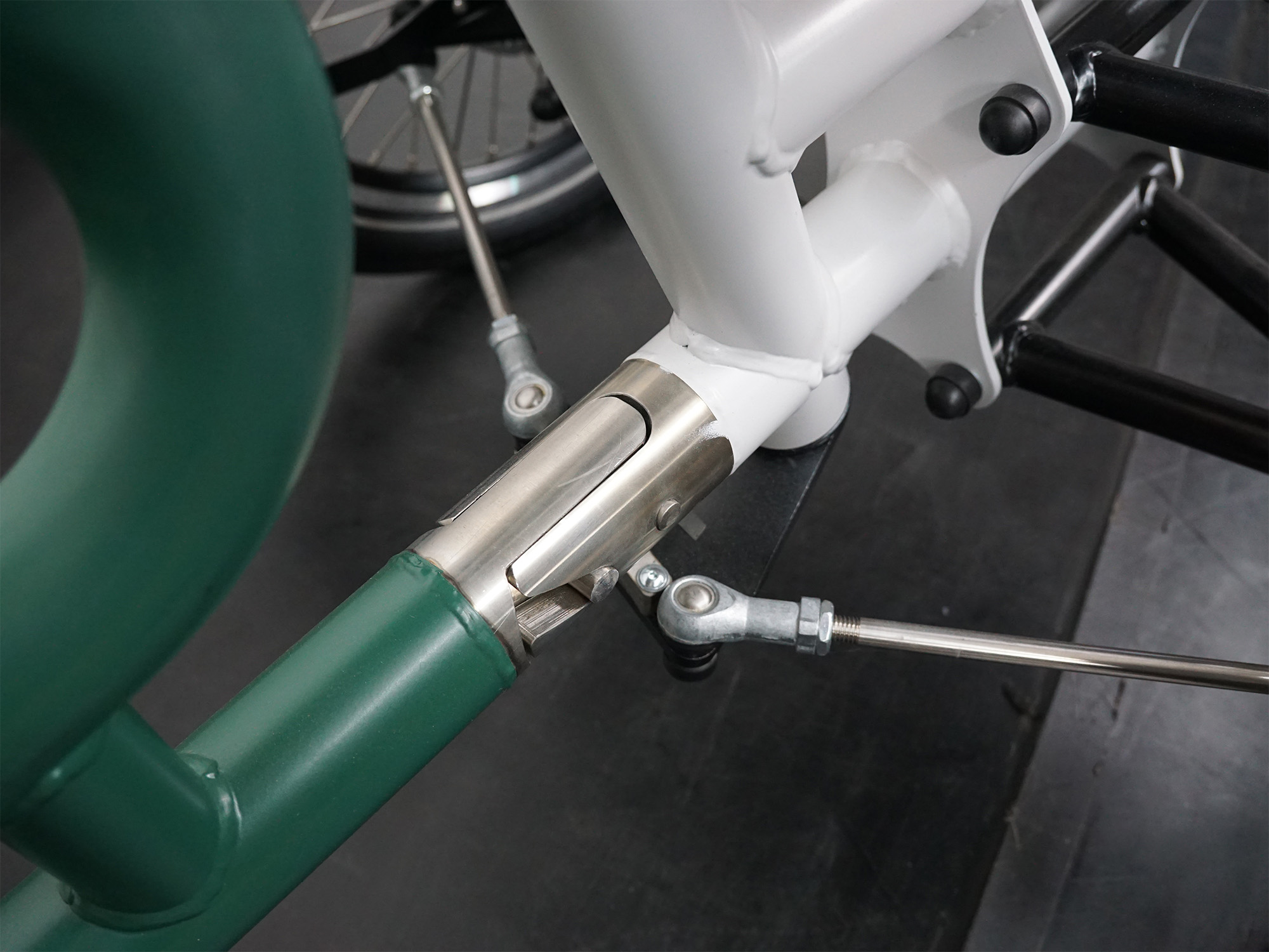 Nahaufnahme eines Gelenkverbinders mit Lenkgestänge an einem Therapierad – präzise Mechanik für Steuerungskopplung.