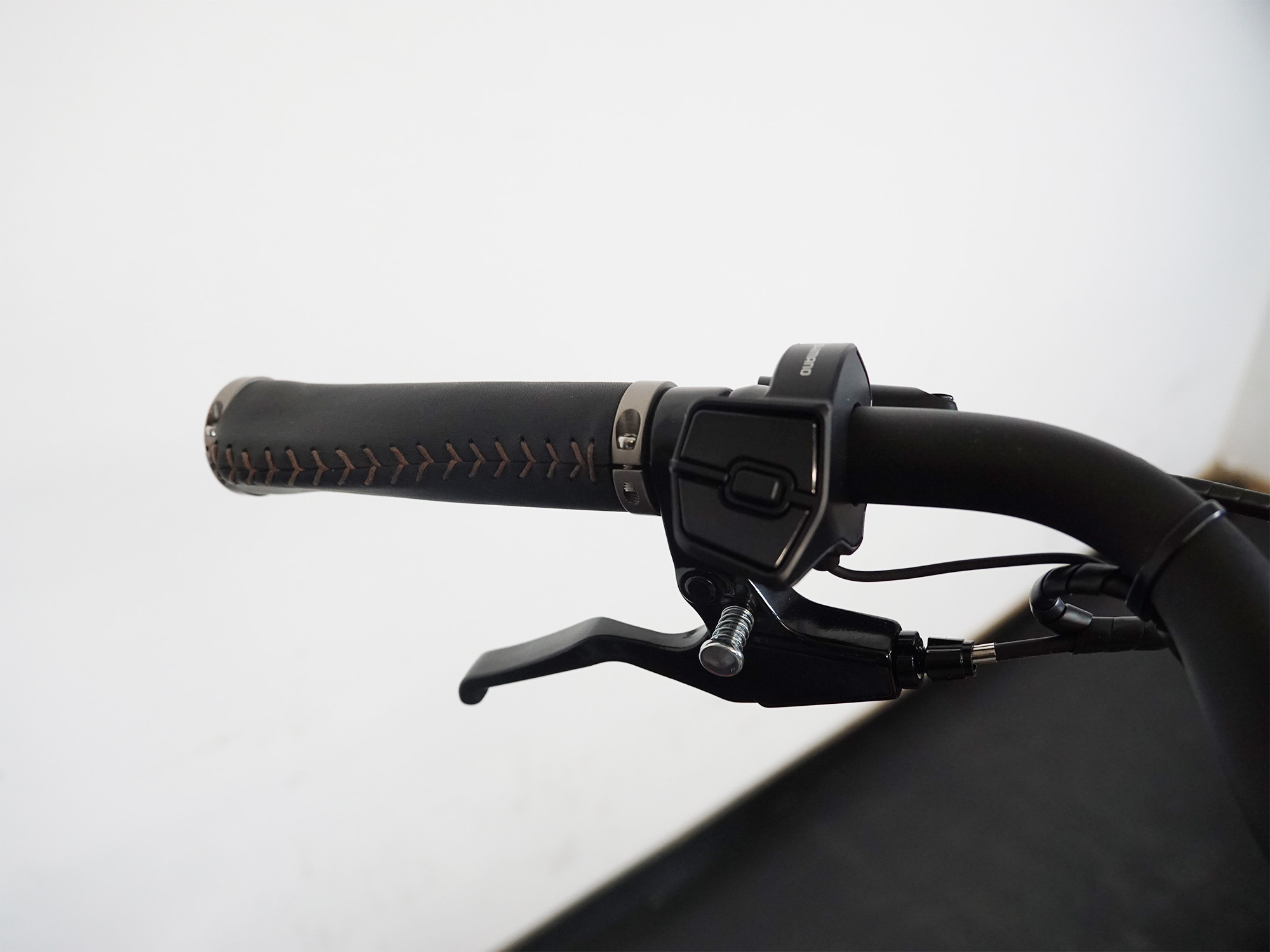 Ergonomischer Ledergriff mit Bedieneinheit und Bremshebel – komfortabel und funktional am Lenker.