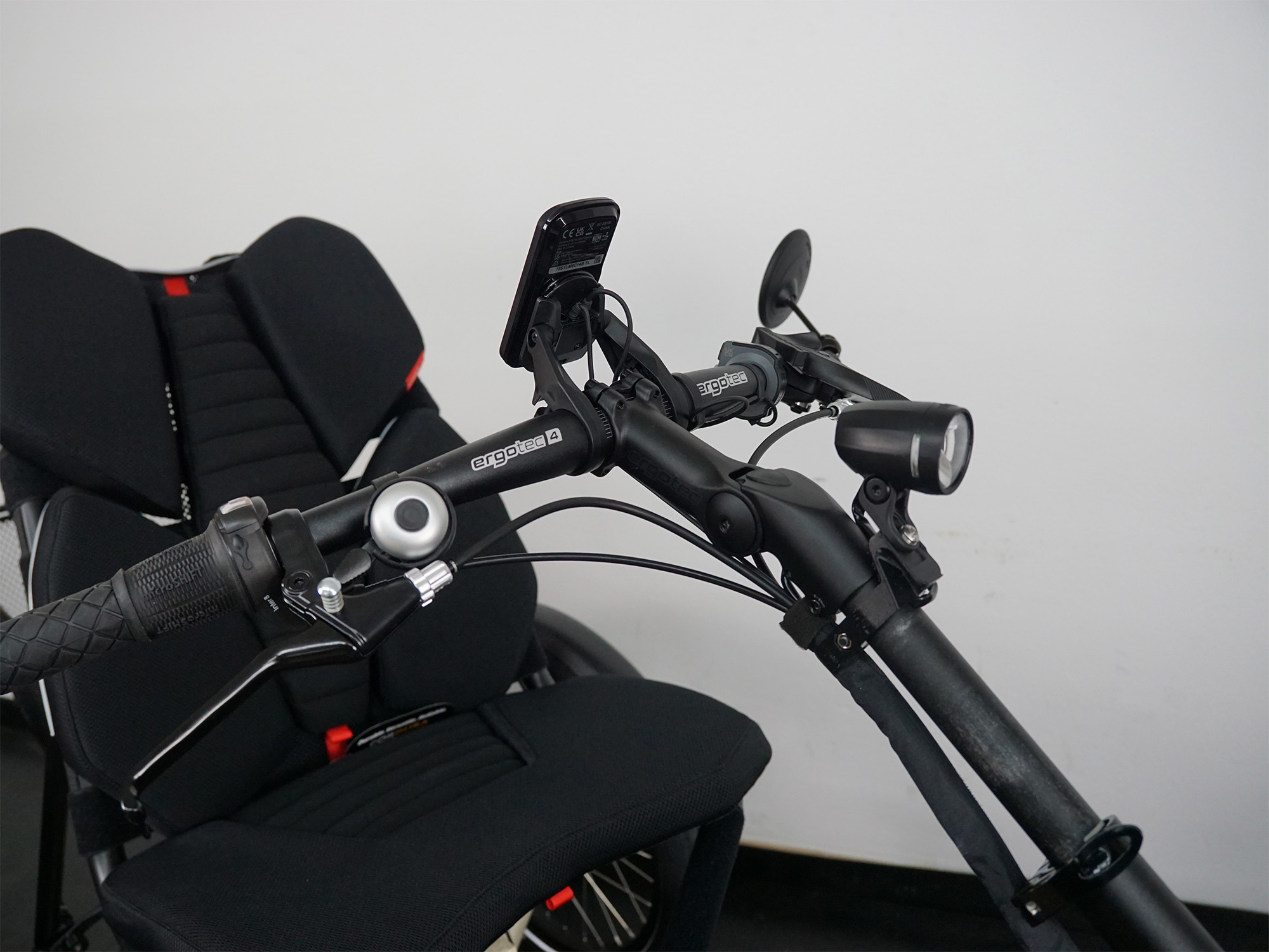 Cockpit eines Liegedreirads mit Display, Klingel, Frontlicht, ergonomischem Netzsitz und Lenker mit Griffschaltung.